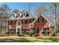 Beautiful brick two-story home featuring dormer windows and a well-manicured lawn at 3395 Hunters Place, Stonecrest, GA 30038