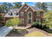 Charming two-story brick home featuring a beautifully landscaped front yard, arched windows and a classic design at 840 Stonehaven Ln, Alpharetta, GA 30005