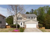 Charming two-story home with a well-maintained lawn and a two-car garage in a suburban setting at 1924 Sweet Flag Rd, Lawrenceville, GA 30045