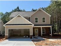 Two-story home features a two-car garage and a covered entryway with stone accents at 48 Beaver Pt, Villa Rica, GA 30180