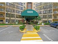 Exterior view of the apartment building entrance with covered awning and well-maintained landscaping at 1800 Clairmont Lk # A427, Decatur, GA 30033