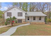Charming split level home featuring stone accents, covered entry porch, and well-maintained front yard at 1143 Cedar Log, Austell, GA 30168