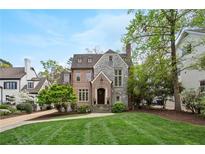Charming stone and brick two-story home with well-manicured lawn and mature trees on a sunny day at 603 E Paces Ferry Ne Rd, Atlanta, GA 30305