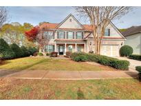 Charming two-story home featuring a well-manicured lawn and a classic brick facade with a two-car garage at 3320 Gardenside Dr, Loganville, GA 30052