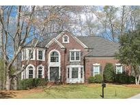 Traditional brick home featuring a manicured lawn and symmetrical design at 2405 Castlemaine Ct, Duluth, GA 30097