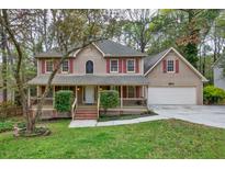 Charming two-story home featuring a covered front porch, attached garage, and traditional architectural details at 2611 Rock Point Ln, Snellville, GA 30039