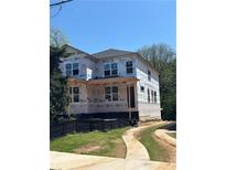 Exterior view of a new home under construction showing windows and Tyvek home wrap with driveway and landscaping at 1236 Oakland Sw Ter # A, Atlanta, GA 30310