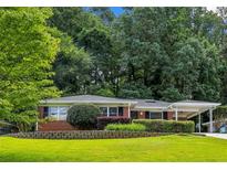 Charming single-story brick home with a well-manicured lawn and a convenient covered carport at 1323 Christmas Ne Ln, Atlanta, GA 30329