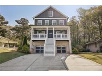 Charming two-story home with a covered porch, set amidst lush trees and an extended driveway at 2525 Reed Se St, Smyrna, GA 30080