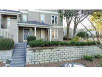 Attractive exterior with a gray stucco facade and well-maintained landscaping and retaining wall at 64 Saint Claire Ne Ln, Atlanta, GA 30324