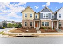 Charming, colorful townhome with manicured lawn, inviting front entrance, and brick accents at 218 Perry Point Run, Lawrenceville, GA 30046