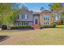 Charming two-story home with gray siding, stone accents, inviting front yard, and blooming trees at 434 Shepard Sw Dr, Marietta, GA 30064