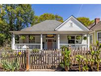 Charming home featuring a welcoming front porch, lush landscaping, and a classic white picket fence at 290 Georgia Se Ave, Atlanta, GA 30312