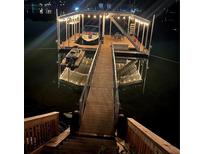 Picturesque dock featuring a boat and jet ski on a peaceful lake at night at 6160 Lake Lanier Heights Rd, Buford, GA 30518