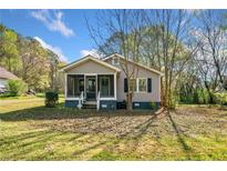 Charming single story home featuring a screened in front porch and a well manicured lawn at 434 Mac Johnson Nw Rd, Cartersville, GA 30121