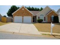 Charming single-Gathering home features a two-car garage, stone accents, and a well-manicured lawn at 681 Nine Oaks Cir, Villa Rica, GA 30180