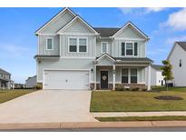 Charming two-story home with a manicured lawn, inviting curb appeal, and an attached two-car garage at 1052 Bodega Loop, Locust Grove, GA 30248