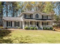 Traditional two-story home featuring a welcoming front porch and black shutters, surrounded by a well-manicured lawn at 3227 Heritage Way, Buford, GA 30519