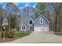 Charming home featuring a well-manicured lawn, two-car garage, and attractive curb appeal at 1007 Springharbor Walk, Woodstock, GA 30188
