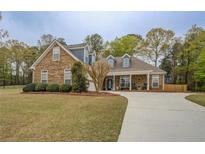 Charming stone and siding home with a well-manicured lawn and a long concrete driveway at 135 Clear Spring Lane, Oxford, GA 30054