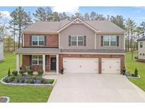 Charming two-story home with a landscaped yard and two-car garage and mixed brick and siding facade at 8033 Louis Dr, Locust Grove, GA 30248