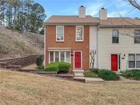 Charming two-story brick townhome with a red door and well-maintained landscaping at 193 High Creek Dr, Roswell, GA 30076