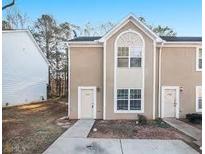 Attractive townhome featuring a symmetrical façade, arched window, and well-maintained landscaping at 2960 Fields Dr, Lithonia, GA 30038
