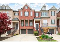 Charming townhome boasts brick facade, a two-car garage, and inviting entry with wrought iron details and manicured landscaping at 1423 Montclair Se Ct # 12, Smyrna, GA 30080