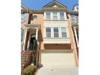 Inviting brick townhome featuring a two-car garage and stylish architectural details at 4621 Wehunt Commons Se Dr # 7, Smyrna, GA 30082
