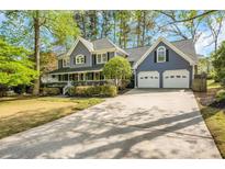 Charming two-story home with attached two-car garage and well-manicured landscaping, including a covered front porch at 3320 Woodsfield Ne Dr, Marietta, GA 30062