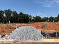 New construction site with pipes and gravel, set against a backdrop of lush trees and blue sky at 6348 Towhee Way, Morrow, GA 30260