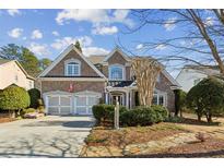 Charming two-story brick home with a two-car garage, manicured landscaping, and a welcoming front entrance at 1239 Bonshaw Trl, Marietta, GA 30064