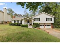 Charming two-story home with a well-manicured lawn, two car garage, and a welcoming front porch at 1068 Gwens Sw Trl, Lilburn, GA 30047