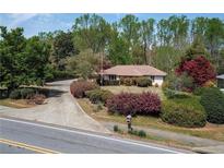 Charming single-story home with mature landscaping and a long driveway at 660 Hembree Rd, Roswell, GA 30076