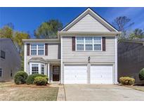 Charming two-story home with a two-car garage and well-maintained front yard at 1037 Dunedin Trl, Woodstock, GA 30188