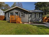 Charming single-story home with a painted brick facade, new deck and well-manicured lawn and landscape at 2189 Gordon Se Cir, Smyrna, GA 30080