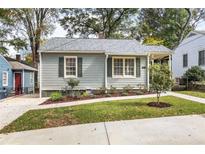 Charming one-story home featuring gray siding, updated windows, a manicured lawn, and a sidewalk at 1257 Lyle Pl, Atlanta, GA 30318