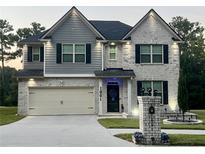 Charming two-story home with brick and gray siding, a manicured lawn, and a two-car garage at 1861 Poplar Falls Ave, Lithonia, GA 30058