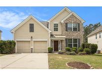 Two-story home featuring a blend of siding and brick, complemented by a well-manicured lawn and a two-car garage at 4355 Rainer Dr, Atlanta, GA 30349