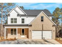 Charming two-story home featuring a brick facade, white siding, and a two-car garage at 4444 Sullivan Rd, Powder Springs, GA 30127