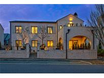 Stunning stone home featuring elegant arched entryway and upper level balcony, all illuminated by warm lighting at 165 2Nd St, Fayetteville, GA 30214