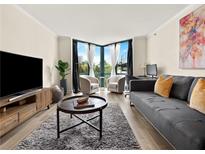 Bright living room featuring hardwood floors, gray sofa and large window with natural light at 2870 Pharr Court South Nw # 504, Atlanta, GA 30305