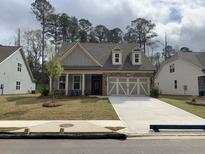 Charming home with a stone accent front, two-car garage, and well-maintained lawn at 89 Mayhaw Pt, Sharpsburg, GA 30277