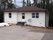 Charming one-story home with white painted brick and siding, updated roof, and inviting entrance at 3543 S Cobb S Dr, Smyrna, GA 30080