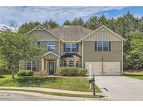 Charming two-story home with a well-manicured lawn, attached two-car garage, and inviting front porch at 349 Pennant Ln, Fairburn, GA 30213