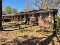 Charming one-story brick home with a covered porch and mature trees at 5804 S South Gordon Sw Rd, Austell, GA 30168