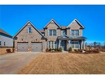 Stunning two-story brick home with a two-car garage and well-manicured front yard in a desirable neighborhood at 7575 Old Camp Lndg, Cumming, GA 30040