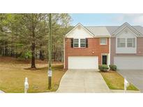 Charming brick townhome featuring an attached garage, driveway, and neatly maintained landscaping at 809 Brickleridge Se Ln, Mableton, GA 30126