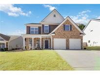 Charming two-story home with brick and siding, inviting front porch, and a two-car garage at 416 Pine Log Ct, Canton, GA 30115