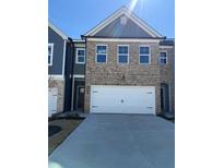 Charming brick townhome featuring a two-car garage and well-manicured front yard at 5633 Hislop Ln # 86, Mableton, GA 30126